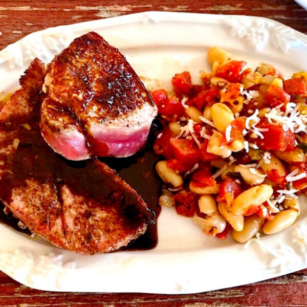 Seared tuna steaks with a balsamic glaze and a white bean and tomato side dish.