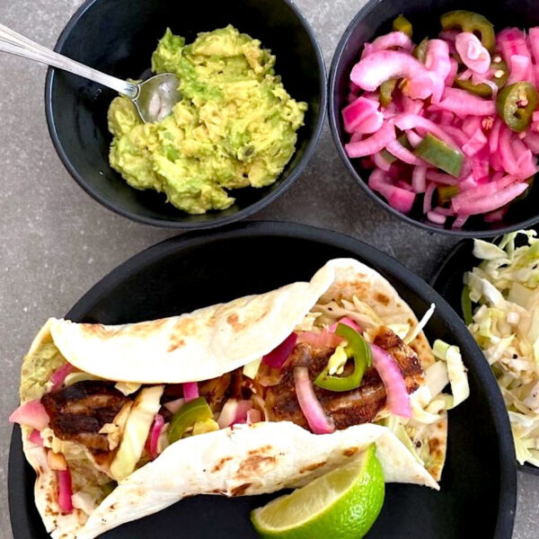 Fish tacos with pickled onions, avocado, and cabbage