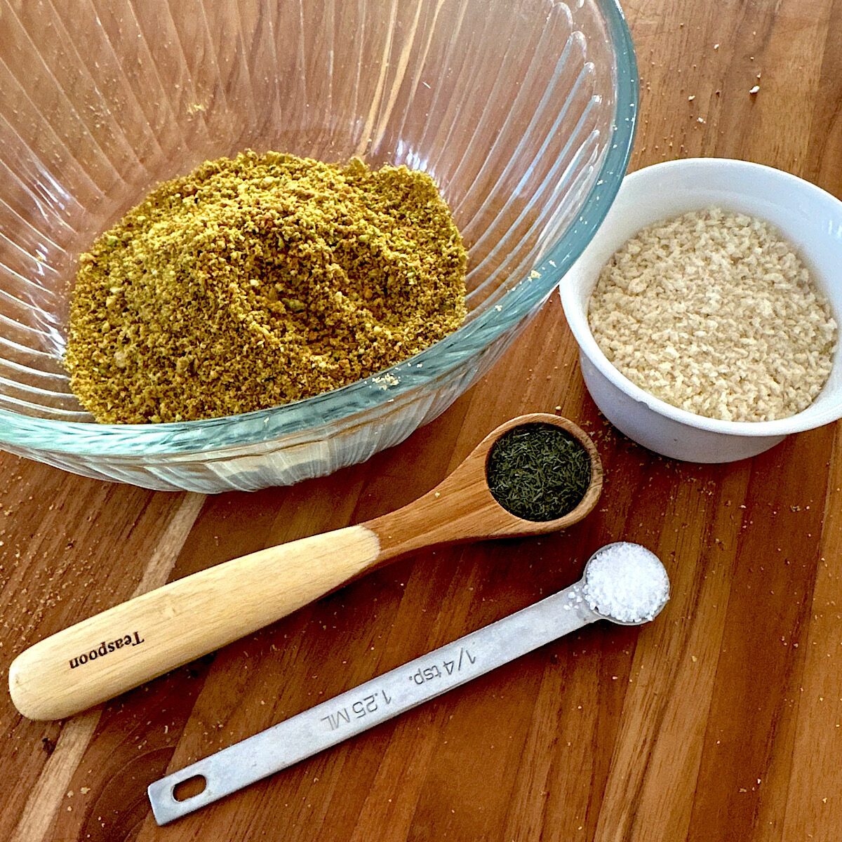 Bowl of ground pistachio nuts, 1/4 cup of panko, a teaspoon of dill and 1/4 teaspoon of salt.