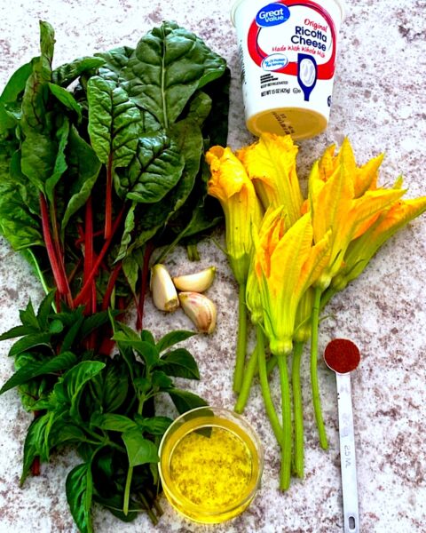 Ingredients for making stuffed squash blossoms: swiss chard, ricotta, squash blossoms, spice and oil.