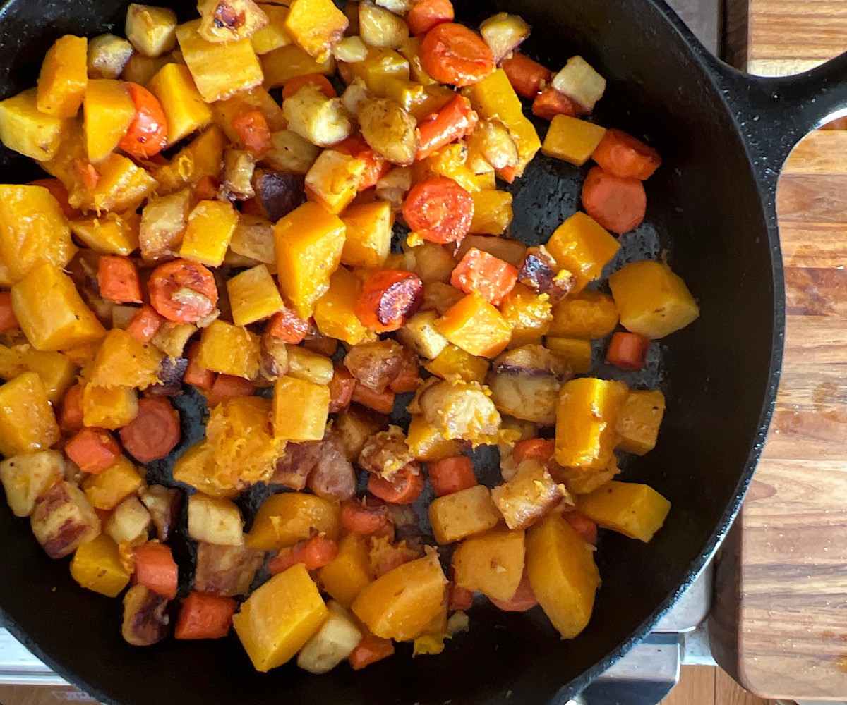Skillet of roasted squash mixed with sauteed parsnips and carrots.