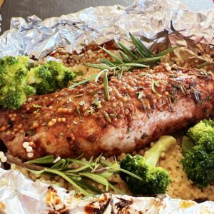 Pork tenderloin with mustard glaze on a bed of orzo pasta and broccoli.