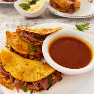 3 beef birria tacos with birria consomme dipping sauce.