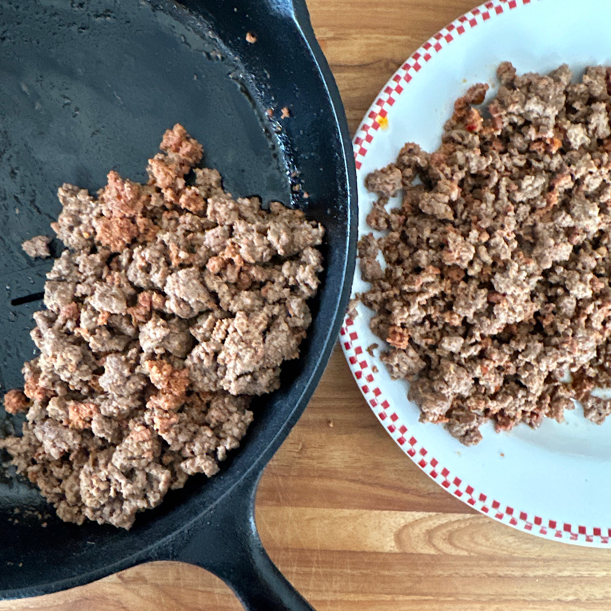 Chorizo and ground beef cooked in skillet and then removed to white plate.