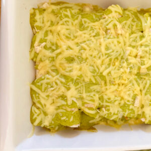 Chicken verde casserole topped with shredded cheese.