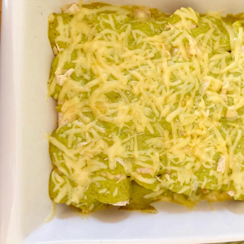 Chicken verde casserole topped with shredded cheese.