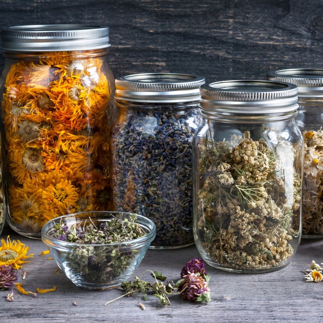 Glass jars with dried tea herbs.