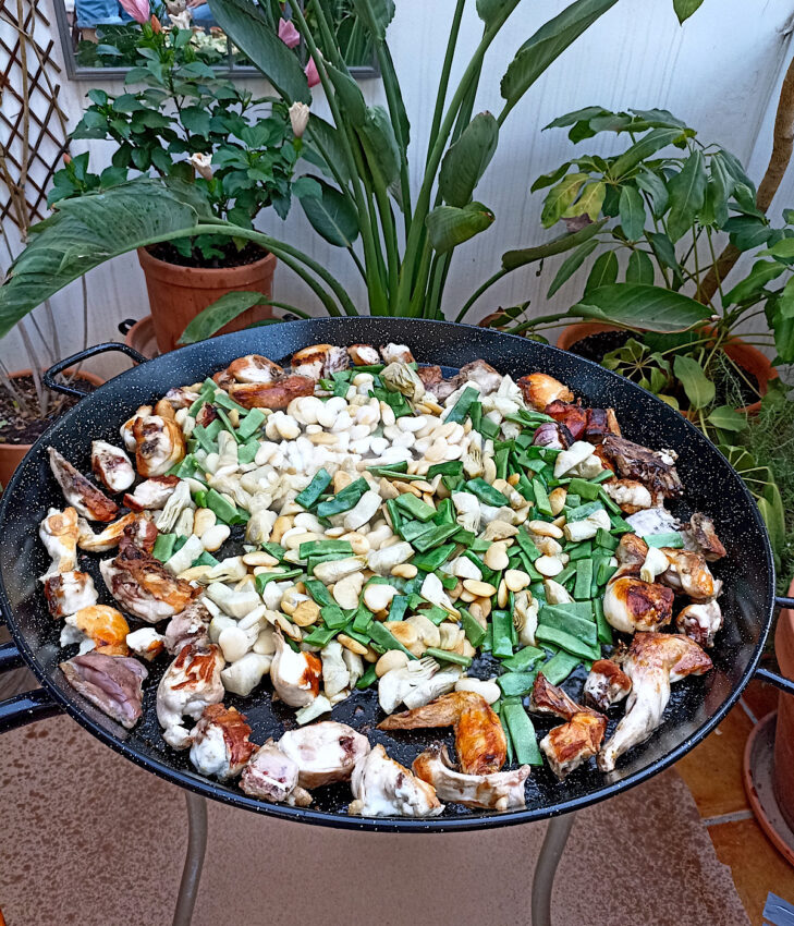 Cooking paella Valenciana with butter beans and runner beans.