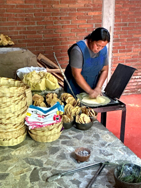 Restaurant worker in Oaxaca using a tortilla press for making tortillas.