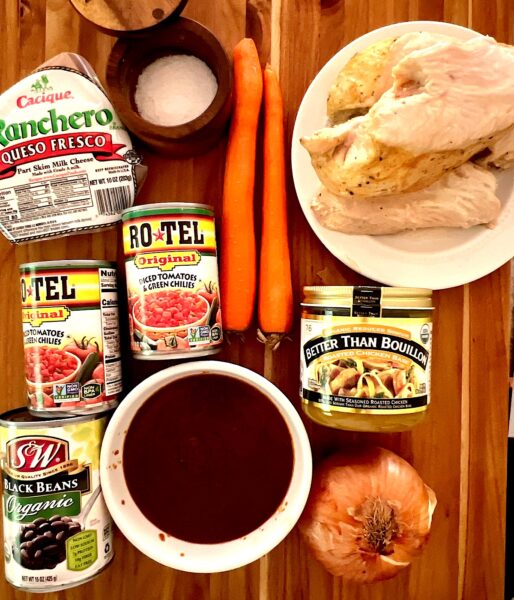 Ingredients for leftover turkey chili with mole sauce laid out on a cutting board.