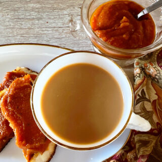 Toast with pumpkin butter, coffee with cream and a side dish of pupmpkin butter.