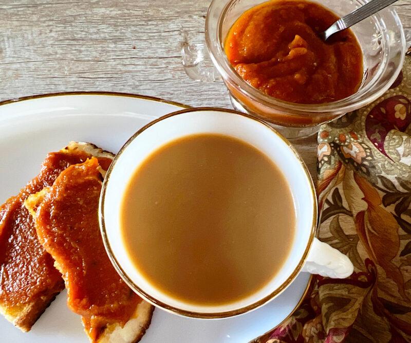 Toast with pumpkin butter, coffee with cream and a side dish of pupmpkin butter.