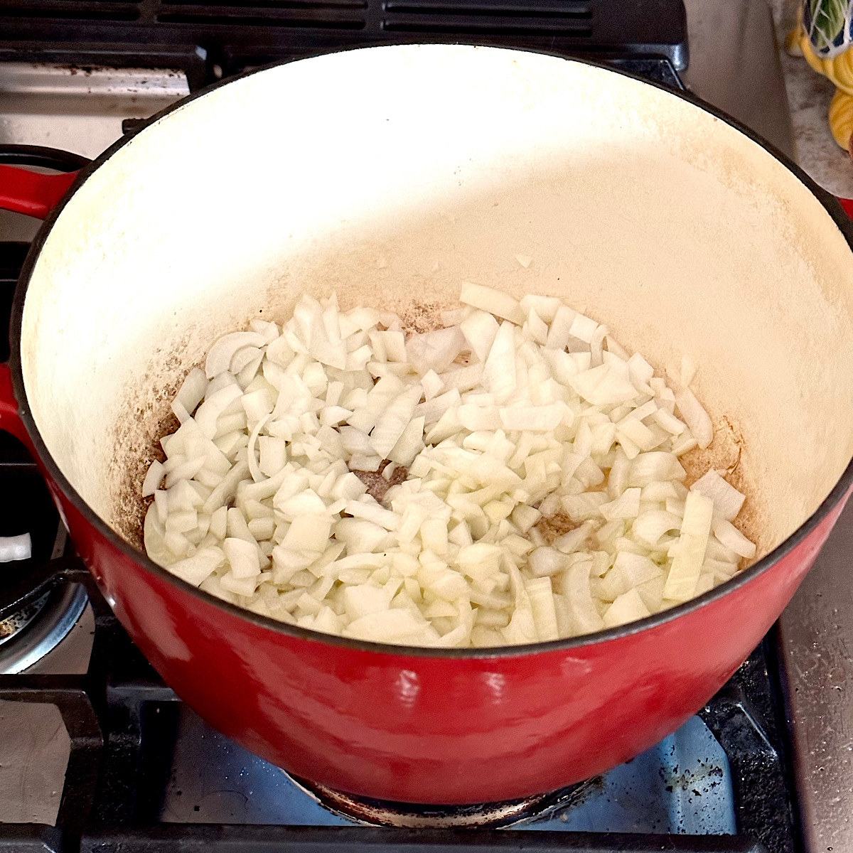 Chopped onions caramelizing in a large dutch oven.
