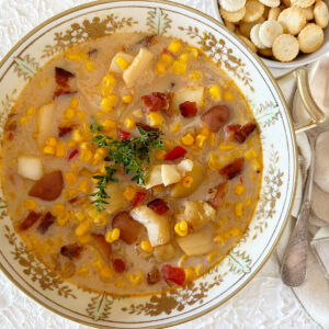 Seafood corn chowder in a large bowl with a side of oyster crackers