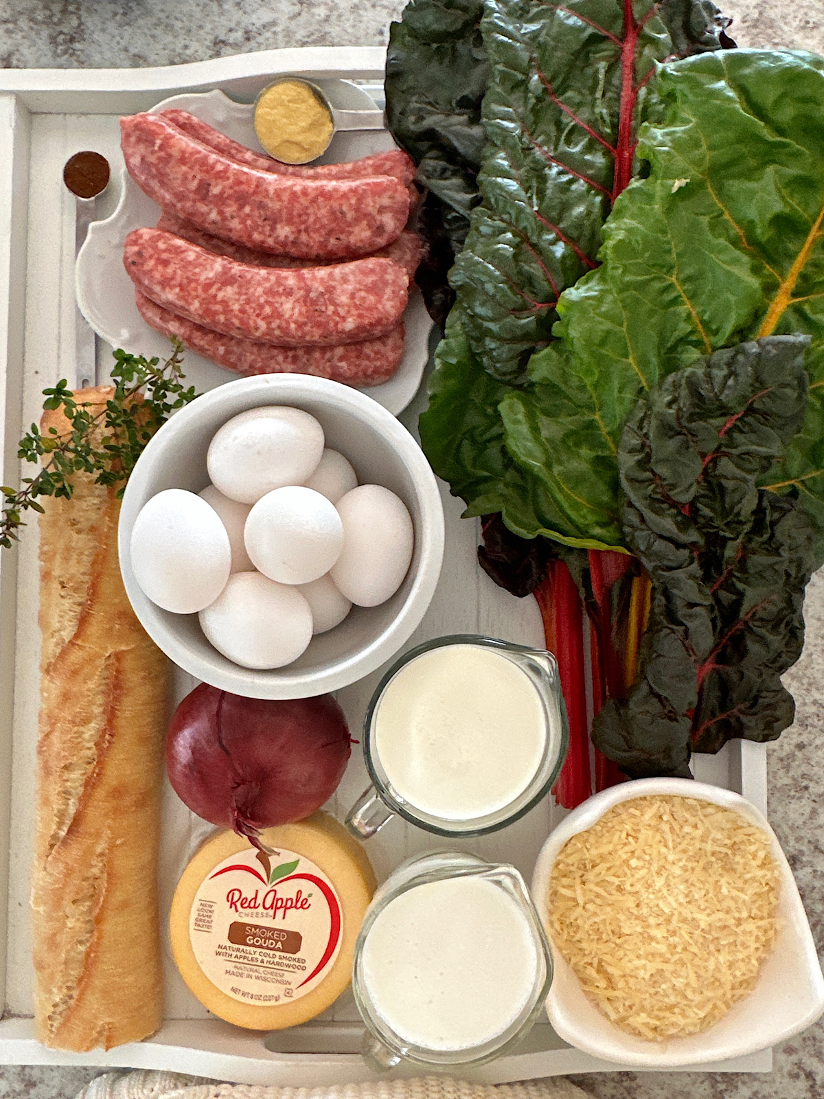 Ingredients for breakfast strata of swiiss chard, sausage and cheese.