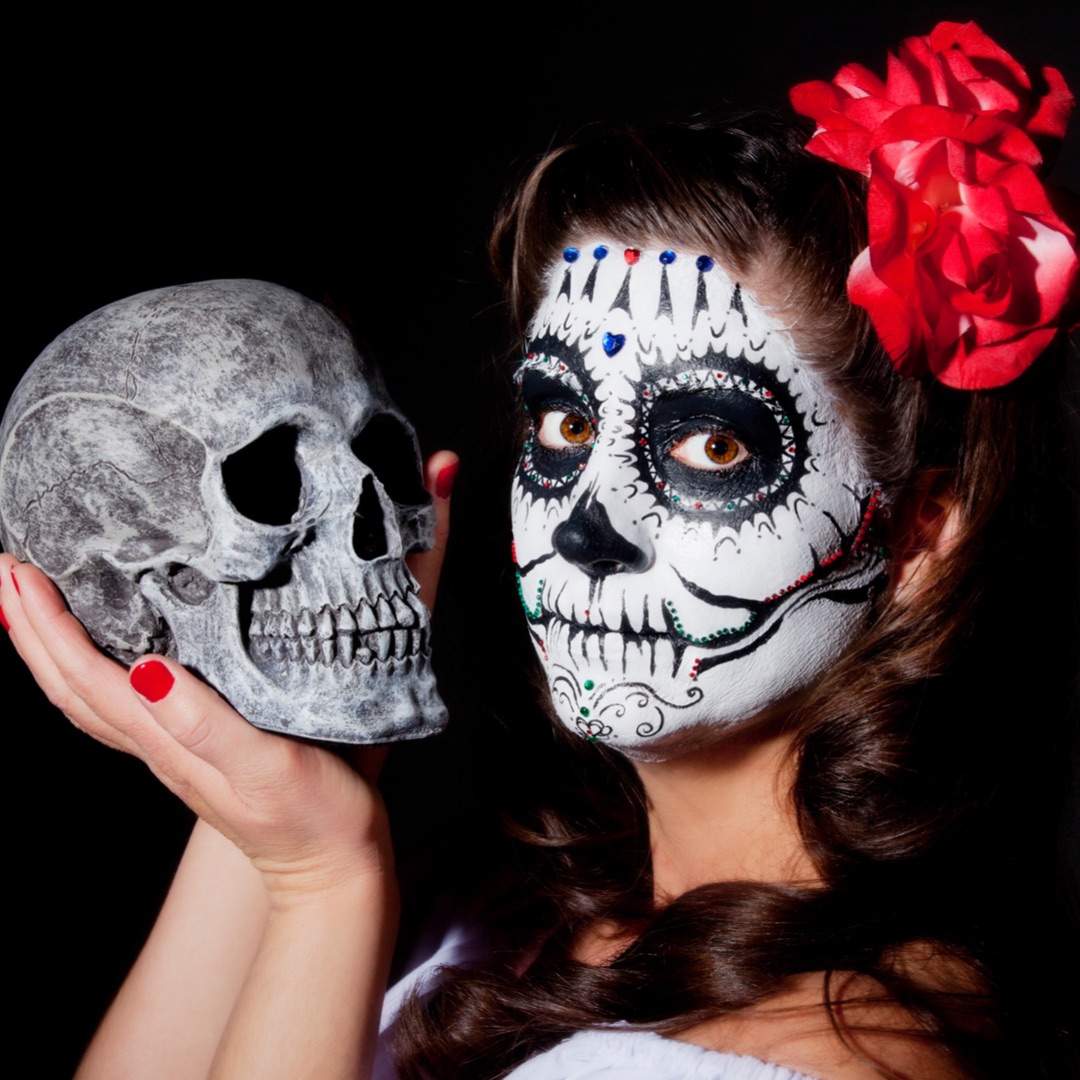 Mexican Day of the Dead girl holding a skull.