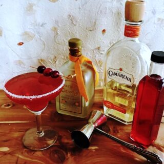 Spicy cranberry margarita wiith bottle of orange liqueur, tequila and cranberry syrup.