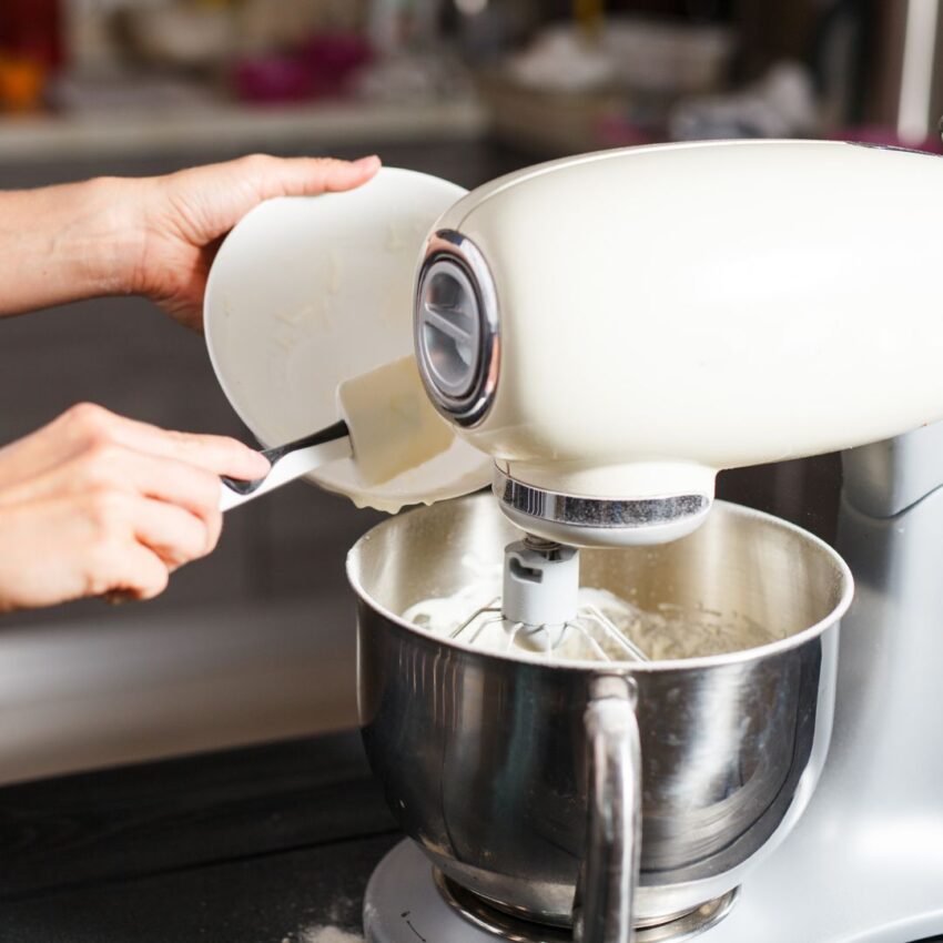 Adding thumbprint cookie dough ingredients to a stand mixer.