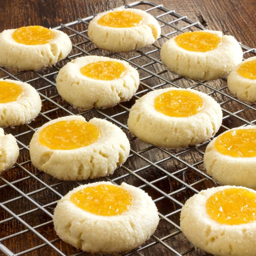 Thumbprint cookies on a baking rack filled with lemon jelly after they were cooled.