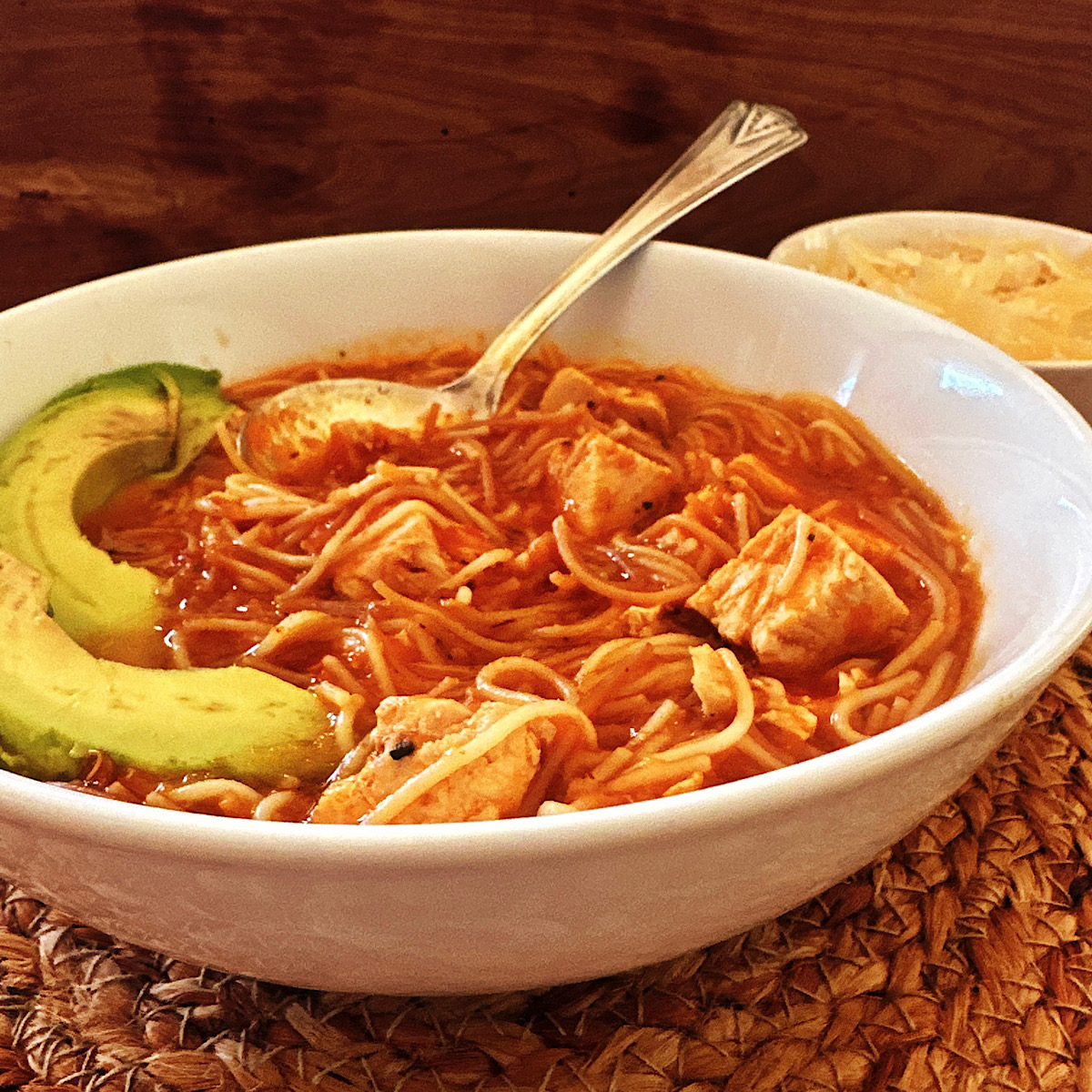 Bowl of Sopa de Fideo (Mexican noodle soup) with leftover turkey and slices of avocado.