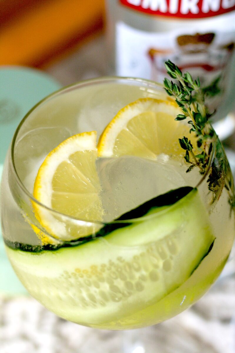 White tea cocktail with sparkling water and cucumber slices with sprig of thyme as garnish.