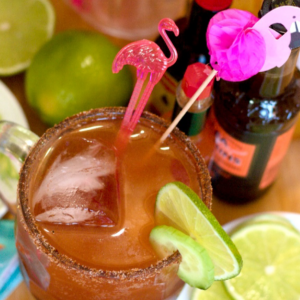 Finished Michelada with flamingo stirrers and lime wedge garnish.