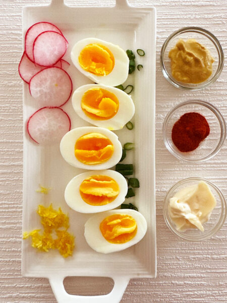 Tray of ingredients for egg salad sandwich, illustrating what the yolk of soft-boiled eggs looks like.