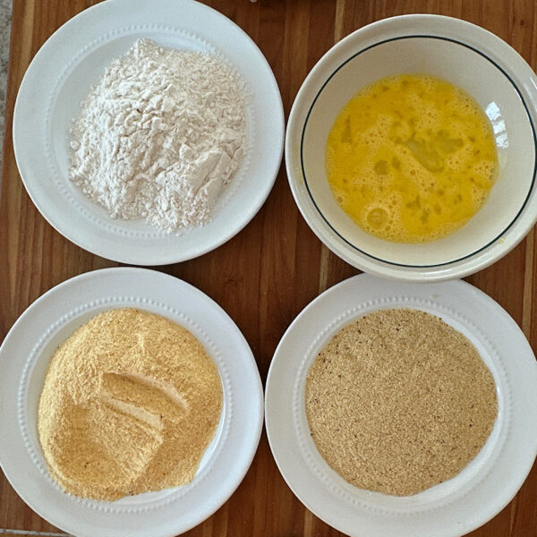 4 bowls with ingredients for breading the catfish: rice flour, egg, spice rub, cornmeal.