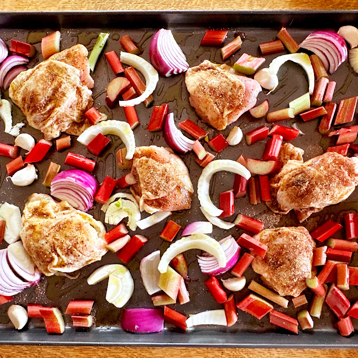 Chicken, rhubarb and  fennel laid out on sheet pan for roasting.