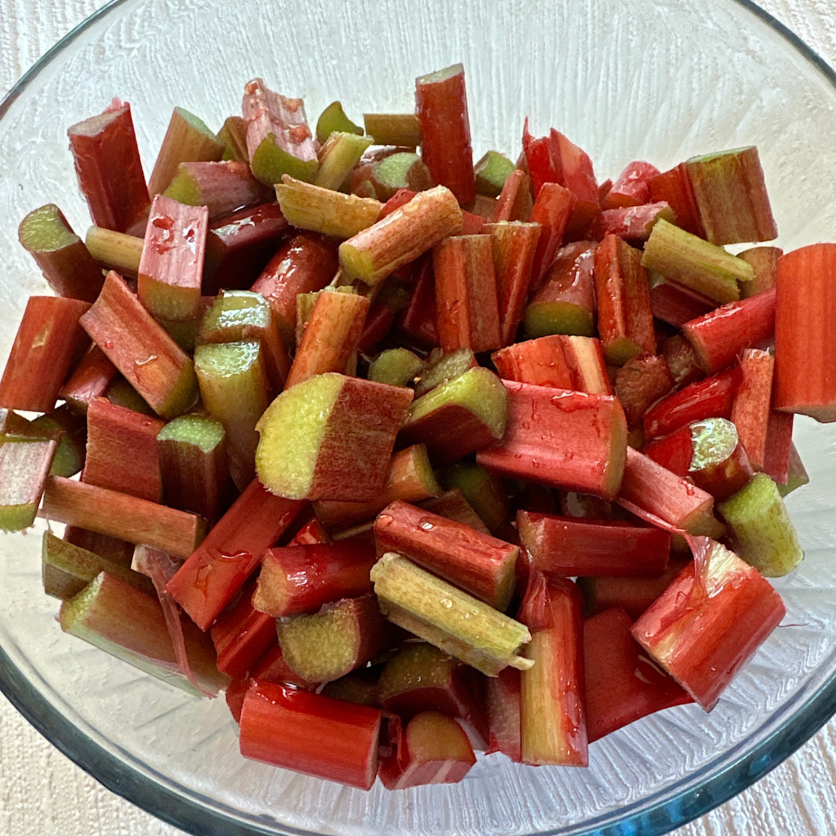 Bowl of sliced rhubarb drizzled with honey.