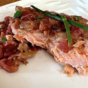 Roasted salmon with a rhubarb topping garnished with green onions.