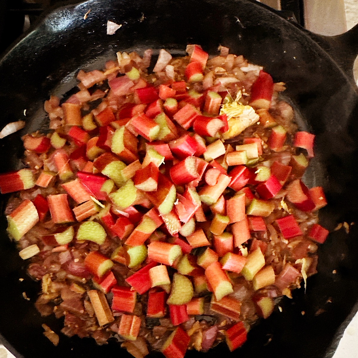Chopped rhubarb cooking in cast iron skillet