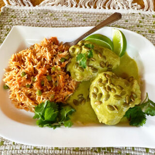 Chicken pipian and Mexican red rice on a white plate.