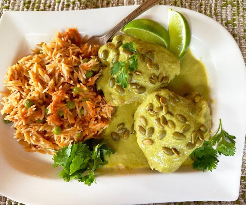 Chicken pipian with Mexican rice on a white plate