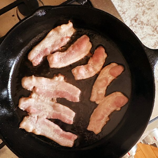 Bacon frying in cast iron skillet