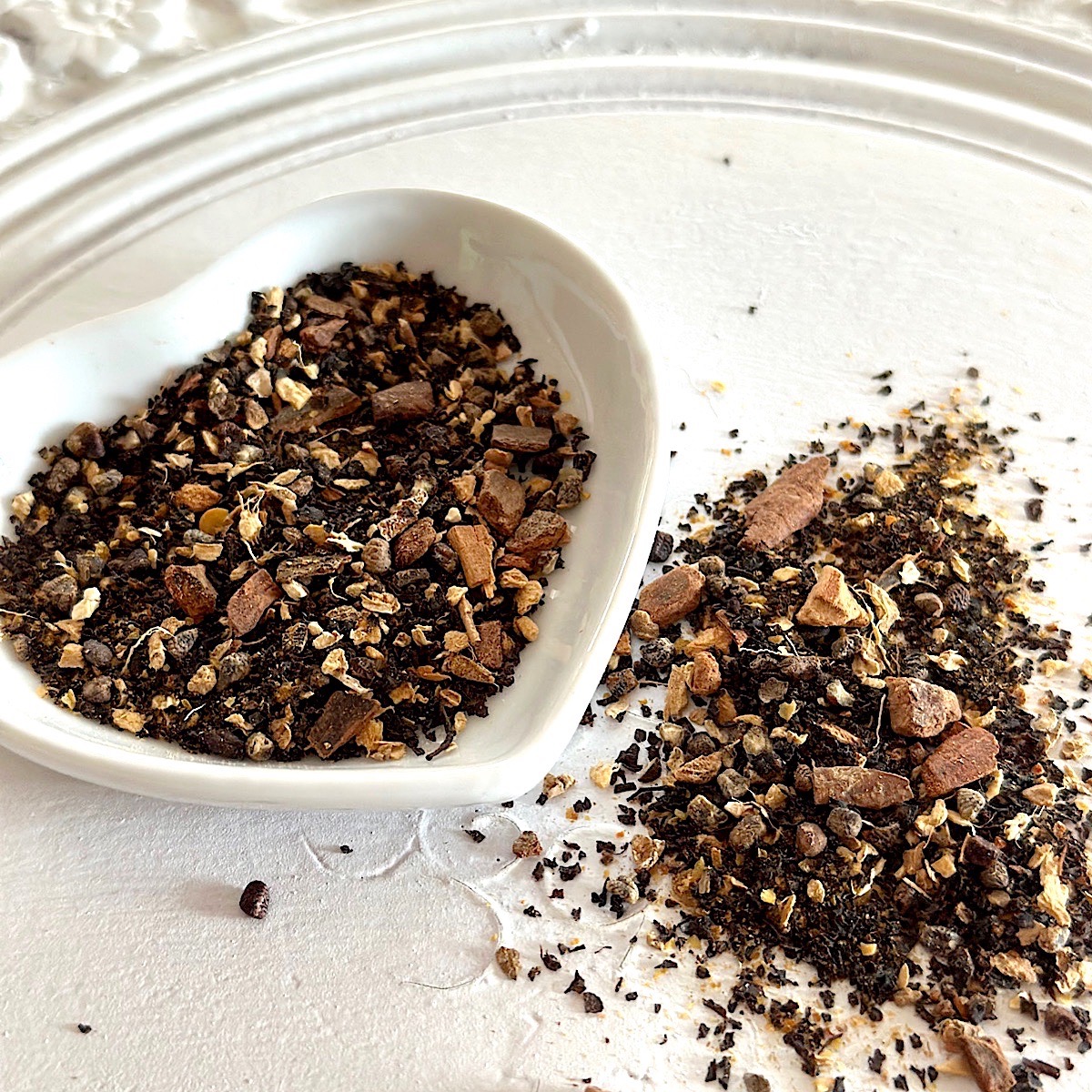 Chai looseleaf tea blend as loose leaf tea, on a white plate.