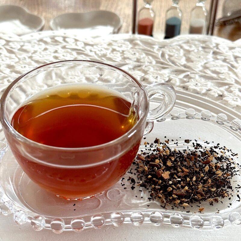Cup of chai tea with loose leaf blend on the side.