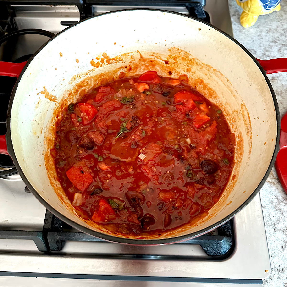 Puttanesca sauce simmering in a dutch oven