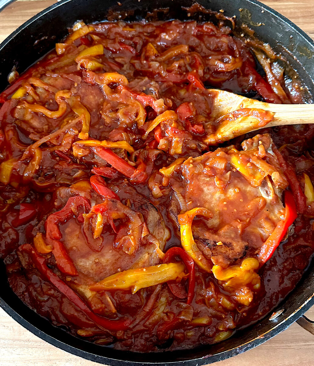 Italian pork chops In a stewed pepper sauce in a skillet