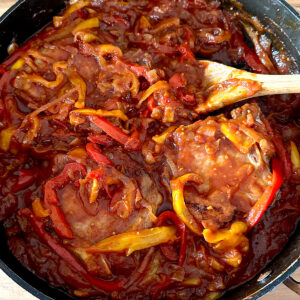 Italian pork chops In a stewed pepper sauce in a skillet