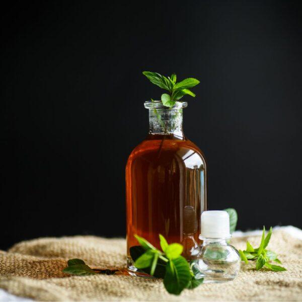 Homemade mint syrup with mint leaves on the side.