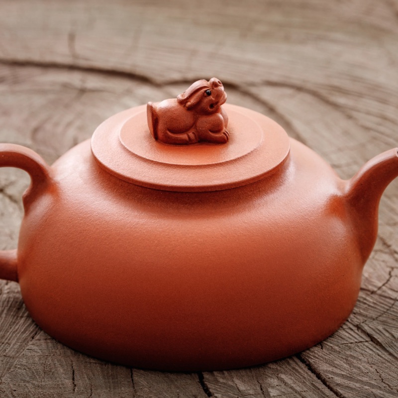 Mexican clay teapot on wood floor.