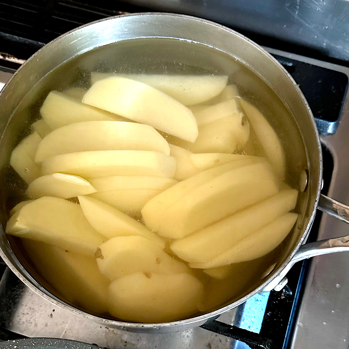 Potato strips cooking in a pot of water