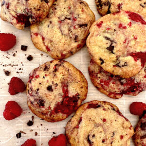 Raspberry chocolate cookies with random raspberries on side.