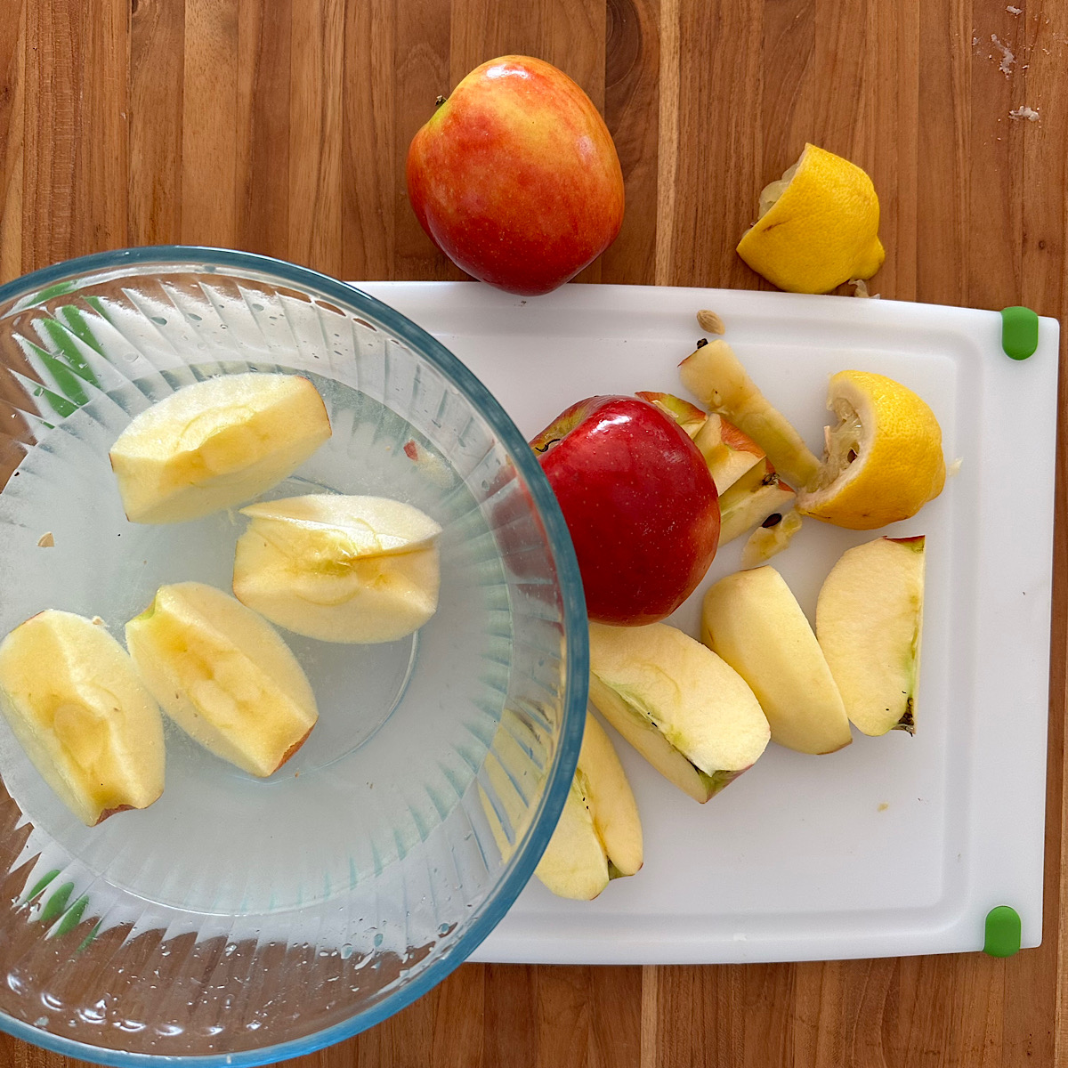 Apples that have been peeled, quartered and cored and placed in lemon water.