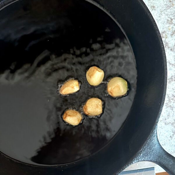 5 cloves of garlic frying in oil