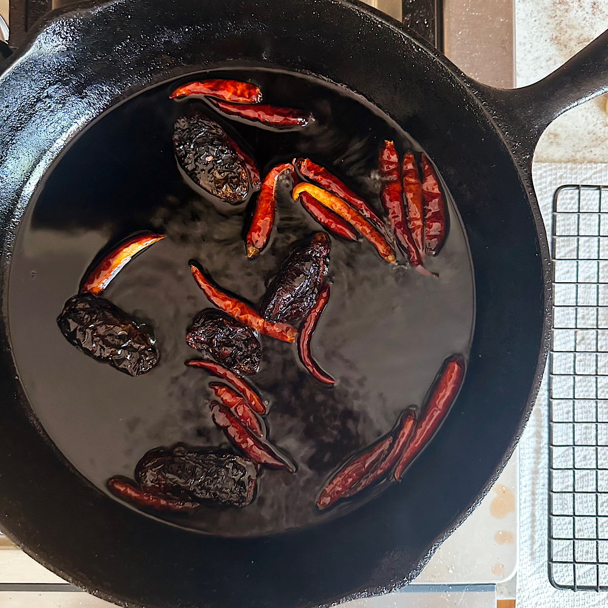 Morita and arbol peppers frying in oil