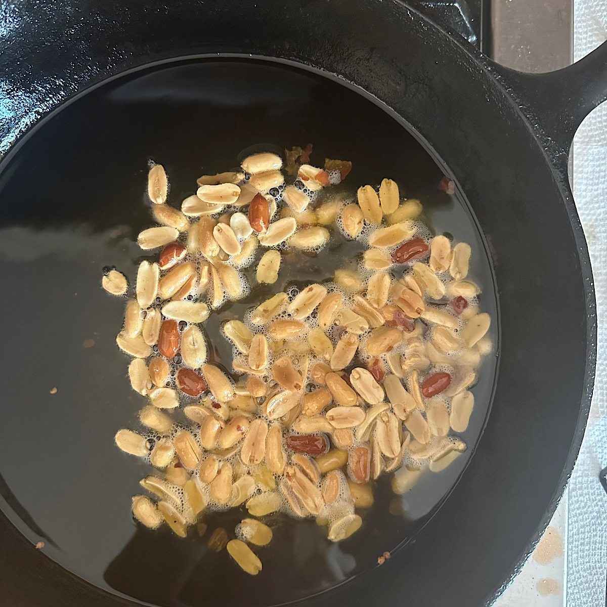 Peanuts frying in a cast iron skillet