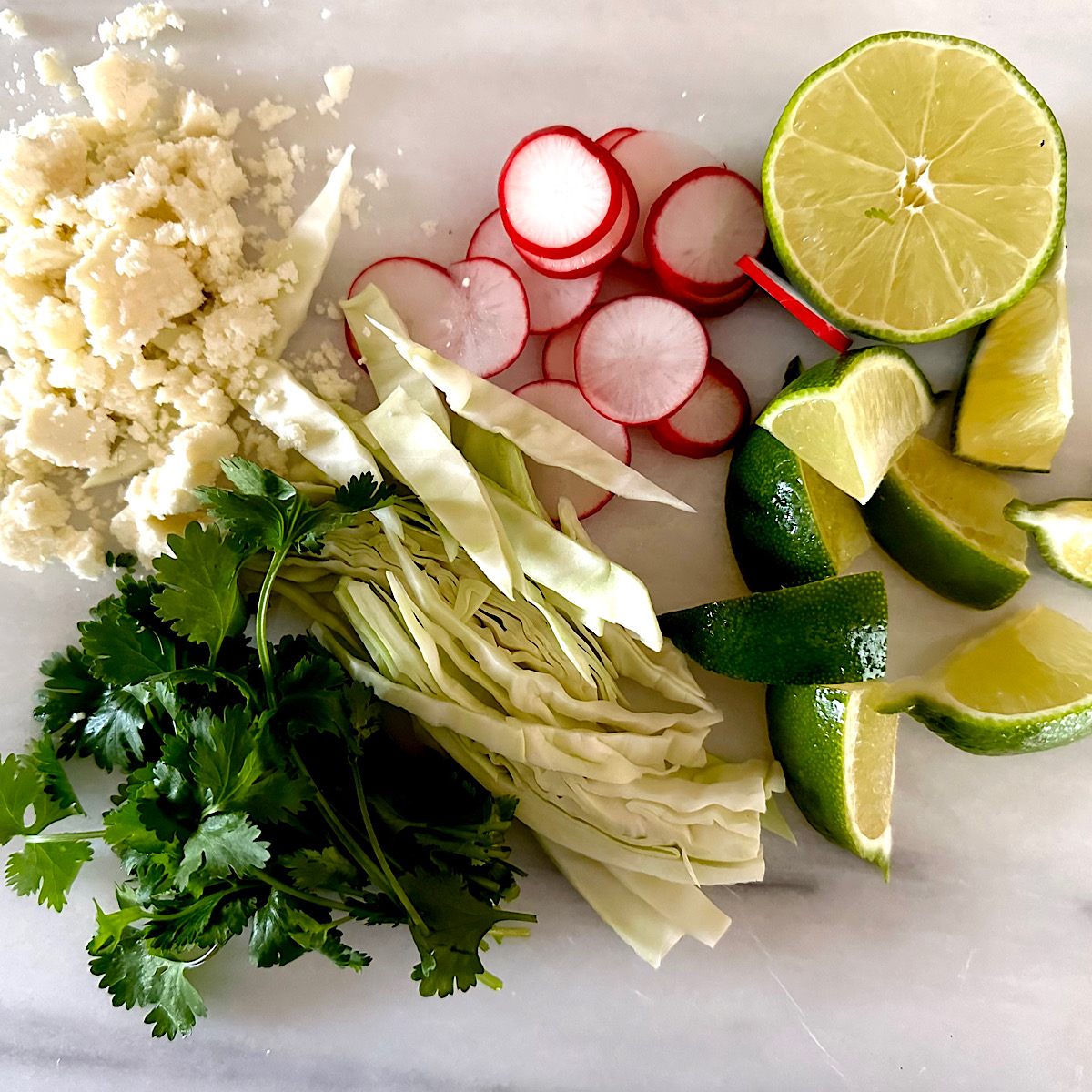 Pozole garnishes; cheese, radish, lime, cabbage and cilantro