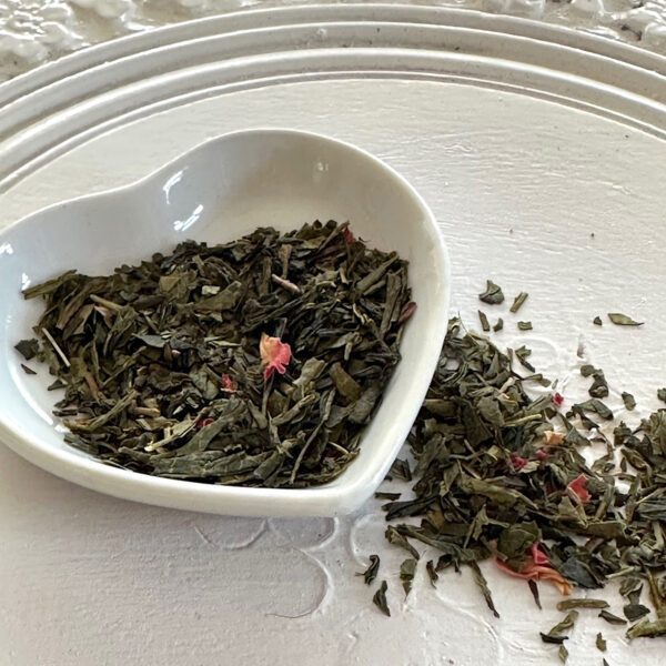 loose green tea and pomegranate in a heart container.